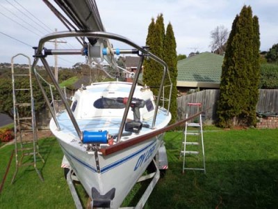 Port gunwale rail laid on the deck at bow end, checking the angles for proper fit tight against the bow plate, prior to starting the fix.