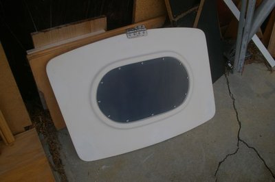 New window cut into front hatch, with tinted plexiglas fixed in with SS self-tappers and white rubber edge strip